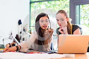 Tailor women or fashion designers work on draft at notebook