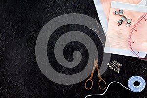 Tailor work place with thread, scissors, fabric. Sewing as hobby. Black background top view space for text