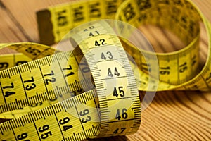 Tailor yellow measuring tape on a wooden table