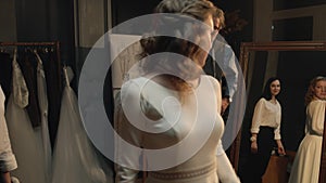 Tailor zips up wedding dress on woman