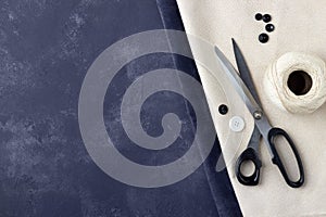 Tailoring concept - sewing accessories on dark blue and beije leather background