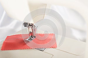 Tailoring process - sewing machine with needle, thread and fabric. Item of clothing