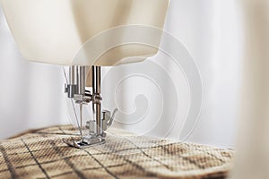 Tailoring process - sewing machine with needle, thread and fabric. Item of clothing