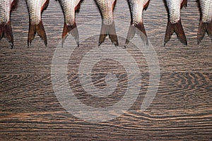 Tails of raw fish onwooden background. Top view. With copy space