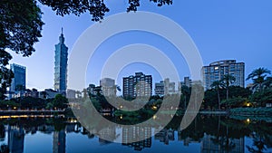 Taipei park garden and reflection of skyscrapers buildings. Financial district and business centers in smart urban city at sunrise