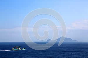 Fishing boat and Guishan Island in the distance photo