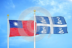 Taiwan and Martinique snake two flags on flagpoles and blue sky