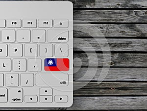 Taiwan Republic of Cina flag enter key on white keyboard, on wood background. 3d render