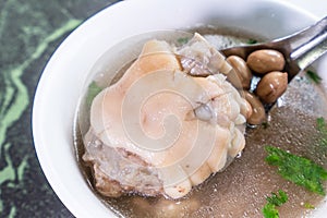 Taiwan`s distinctive famous snacks: Peanut pork knucklepig`s trotter soup in a white bowl on stone table, Taiwan Delicacies