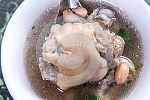 Taiwan`s distinctive famous snacks: Peanut pork knucklepig`s trotter soup in a white bowl on stone table, Taiwan Delicacies