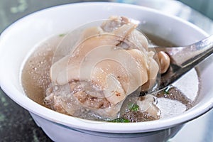 Taiwan`s distinctive famous snacks: Peanut pork knucklepig`s trotter soup in a white bowl on stone table, Taiwan Delicacies