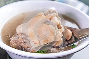 Taiwan`s distinctive famous snacks: Peanut pork knucklepig`s trotter soup in a white bowl on stone table, Taiwan Delicacies