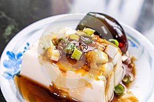Taiwan`s distinctive famous snacks: thousand-year-old eggs tofupidan tofu in a white plate on stone table, Taiwan Delicacies