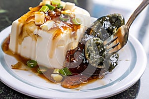 Taiwan`s distinctive famous snacks: thousand-year-old eggs tofupidan tofu in a white plate on stone table, Taiwan Delicacies