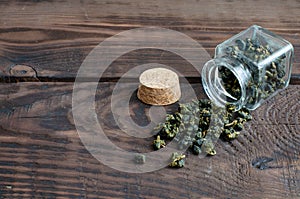 Fresh oolong tea from Alishan mountain in small bottle on wooden background with copy space