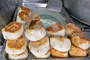 Taiwanese pan fried pork buns Sheng Jian Bao at food street market in Kaohsiung, Taiwan.