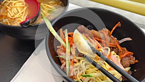 taiwanese style cold dry noodle half boiled egg cuisine asian food in black plate with chopsticks to get boiled