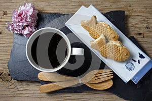 Taiyaki cakes with coffee on wood background