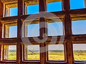 Taj Mahal behind bars - panoramic view of fields with Taj Mahal in background from Agra Red Fort