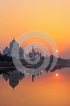 Taj Mahal reflected in Yamuna river at sunset in Agra, India