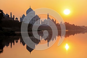 Taj Mahal reflected in Yamuna river at sunset in Agra, India photo