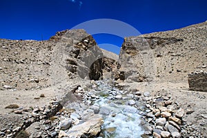 Tajikistan. Mountain stream flowing down the canyon with the bar