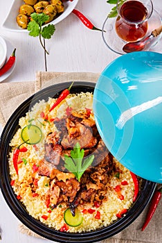 A Tajin with couscous, vegetables and meat on white background