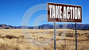 Take Action Just Ahead brown road sign