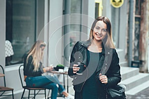 Take away coffee. Beautiful young urban woman wearing in stylish clothes holding coffee cup