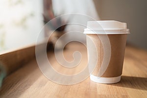 Take away coffee cup with lipstick mark on wooden table in small coffee cafe