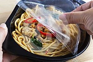 Take-away food ready meal: Woman hands holding open cling wrap a