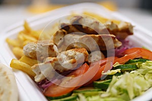 Take away kalamaki served in a lunch box in a Greek fast food restaurant. Traditional Mediterranean meat dish