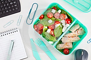 Take away lunch box with fresh salad and tuna fish over the offi