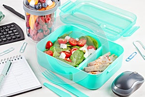 Take away lunch box with fresh salad and tuna fish over the offi