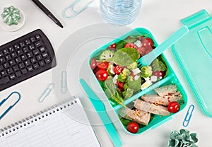 Take away lunch box with fresh salad and tuna fish over the offi