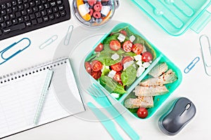 Take away lunch box with fresh salad and tuna fish over the offi