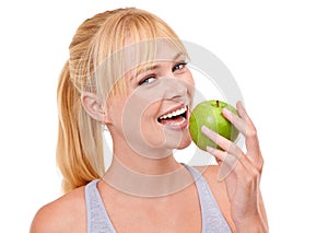 Take a bite for health. Studio portrait of an attractive young woman eating an apple isolated on white.