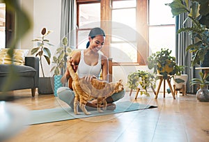 Take a break and pet me. Shot of a sporty young woman petting her cat while exercising at home.