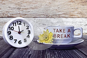 Take a break text written on white coffee cup with clock set at 2 o'clock.