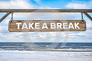 Take a break wooden sign against beach