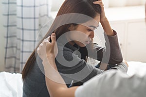 Take care of depressed people. Friend touching shoulder of sad young woman and soothe photo