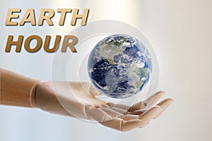 Take care of Earth, turn off lights for hour. Wooden mannequin hand with globe illustration on light background