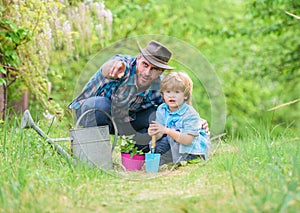 Take care of plants. Boy and father in nature with watering can. Gardening tools. Planting flowers. Dad teaching little