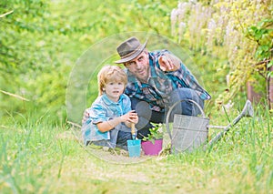 Take care of plants. Boy and father in nature with watering can. Gardening tools. Planting flowers. Dad teaching little