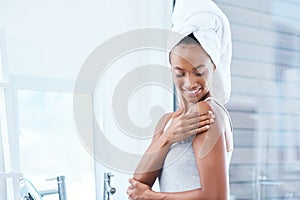 Take care of the skin youre in. a young woman applying moisturizer to her body.