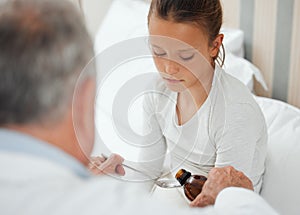 Take care of your body. Its your only place to live. Shot of a doctor giving a little girl some medicine at home.