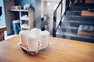 Take coffee to work for the entire office. High angle shot of a cardboard take out tray with four coffee cups with lids