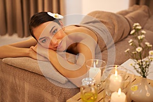 Take a day to destress. A beautiful young woman relaxing on a massage table before her massage.