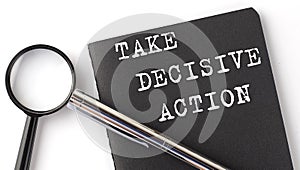 TAKE DECISIVE ACTION - business concept, magnifier with white text message on the black notebook