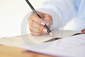 Take the exam final high school university student holding pencil writing on paper answer sheet - education college in class